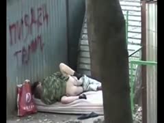 In an immodest public setting, an amateur photographer witnesses a homeless couple beating each other.